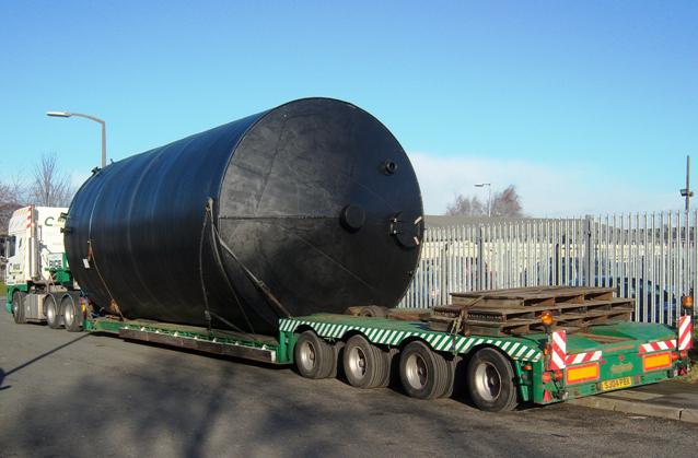 A large fabricated vessel secured for road transport.
